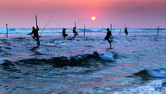 Silhouettes of the traditional stilt fishermen at sunset near Galle in Sri Lanka, South Asia