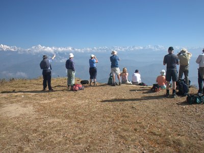 Ramble Worldwide walking group admiring Himalayan vista of atop mountain, Nepal 
