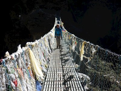 Person walking along bridge to tea house, Nepal