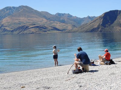 People enjoying view of Lake Wanaka from shore, New Zealand