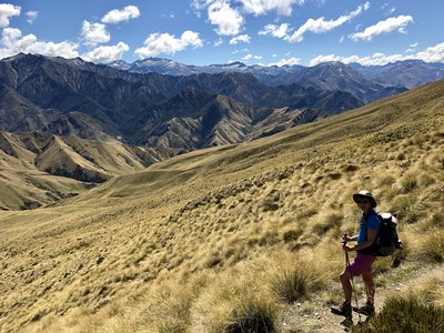Hiker standing along Moonlight Track with expansive mountainous landscape, New Zealand