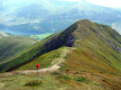 Solo walker on Ramble Worldwide walking holiday making good pace down pathway on Causey Pike, Buttermere, Lake District