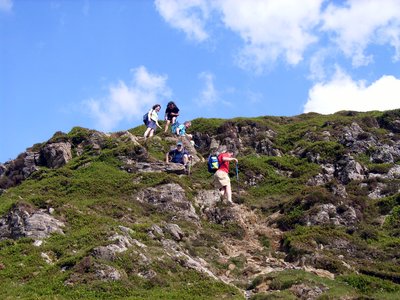 Walking group steadily stepping down hill on Great Gable in Buttermere in the Lake District, United Kingdom