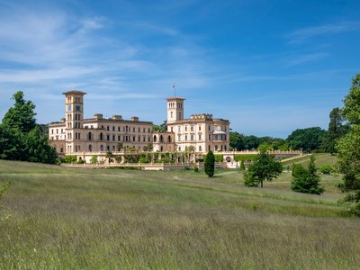 Osborne House viewed from distance in long grass field, Isle of Wight, South East England, UK