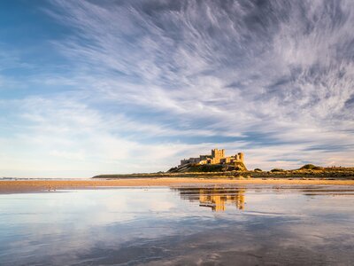 Bamburgh castle reflecting in the wet sand, Bamburgh, England