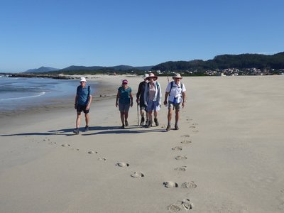 Group of walkers on beach moving towards camera, Algarve, Portugal