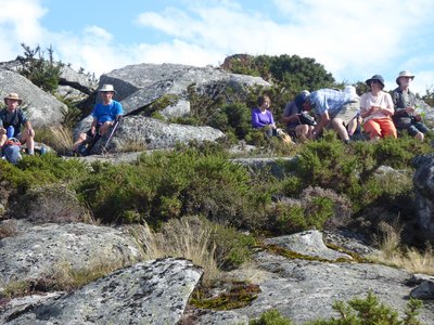 Walking group sat on rocks taking a break enjoying scenery, Algarve, Portugal