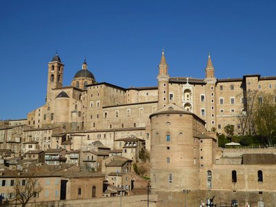 Urbino cityscape showing Italian architecture and Ducal Palace against clear blue sky background in Italy