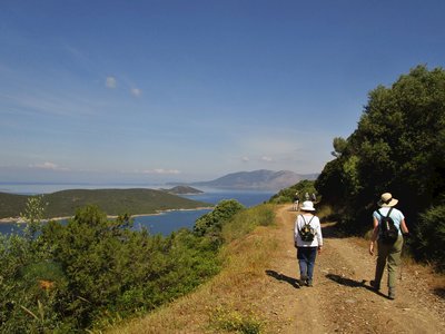 Ramble Worldwide walking holiday following dirt pathway to Marmari in Greece with coastal view of green islands and sea with blue skies