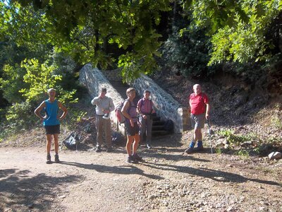 Walking group of 5 people standing during break near stone stairway, Greece