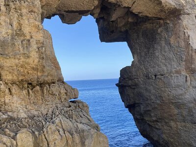Natural coastal rock arch bridge framing Mediterranean sea, Malta
