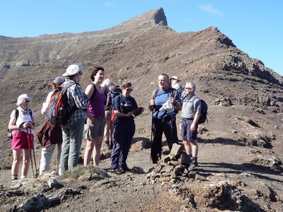 Walking group on mountain pausing to chat and admire view, Fuerteventura, Canary Islands, Spain