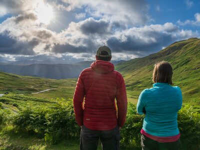 Walkers admiring Lake District view from Honister Pass, Lake District, England