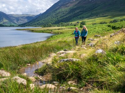 Two women walking through Buttermere Valley in the Lake District