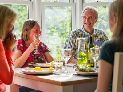 Ramble Worldwide walking holiday group enjoying meal in sunlit dining room of Hassness House