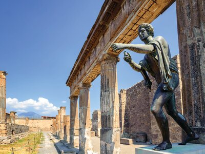 Temple of Apollo with bronze statue of Apollo reaching out from beneath stone pillars in Pompeii, Naples, Italy, Europe