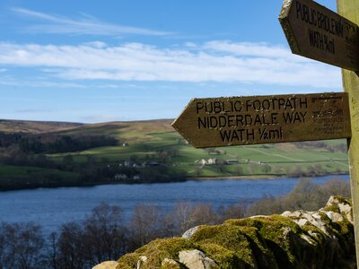 Wooden rural trail sign along the Nidderdale Way adjacent to the Gouthwaite Reservoir, Nidderdale, North Yorkshire, England