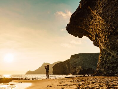 Woman with camera on Monsul beach, Spain