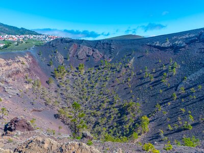 San Antonio Volcano crater with pine trees growing and Los Canarios village in background, La Palma, Spain