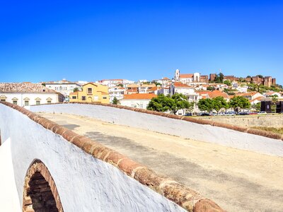 Roman bridge in Silves with medieval castle in background, Algarve, Portugal
