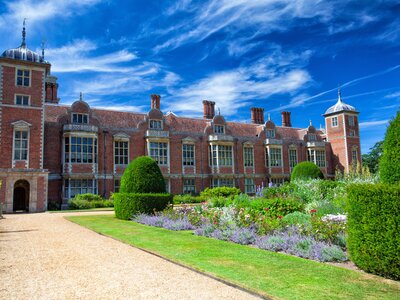 17th century stately home building Blickling Hall with colourful flowers neatly grown outside estate, Blicking, Norwich, England