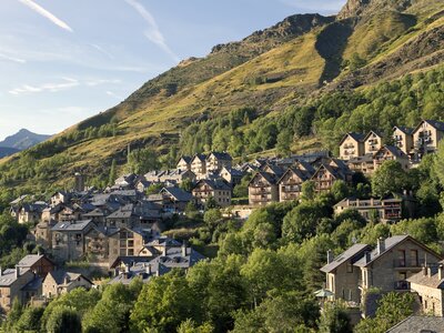 High mountain Boi village nestled in mountainside in Catalan Pyrenees with sun shining upon mountainside, Taull, Boi, Spain