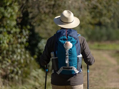 Behind of a pilgrim walking on his way to Santiago de Compostela on a rural pathway, Way of saint James, Camino de Santiago