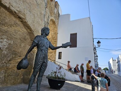 Ramble Worldwide walking group taking short break by staircase next to statue of Juan Relinque, Vejer de la Frontera, Cadiz, Spain