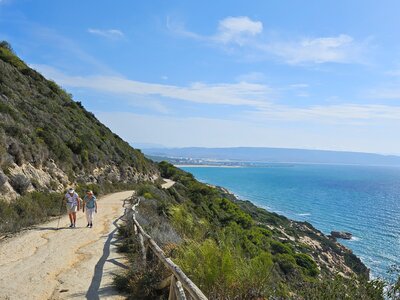 Two women on Ramble Worldwide walking holiday enjoying conversation whilst on coastal path incline on sunny day in Andalucia, Spain