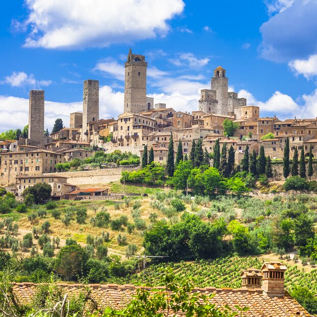 Medieval San Gimignano seen from afar amongst hilly landscape, Tuscany, Italy