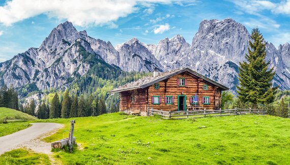 Scenic mountain landscape in the Alps with traditional old mountain chalet and fresh green meadows in springtime, Germany