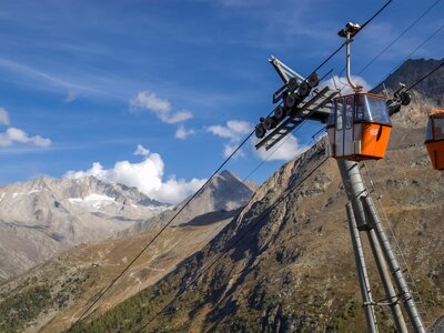 Two small red cable car cabins against the backdrop of the gorgeous mountains near the village of Saas-Fee