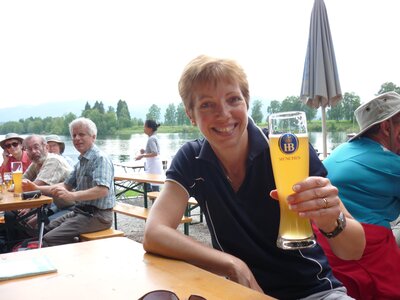 Ramble Worldwide leader Jane Sargeant smiling whilst holding German beer in beer garden, Bavaria, Germany