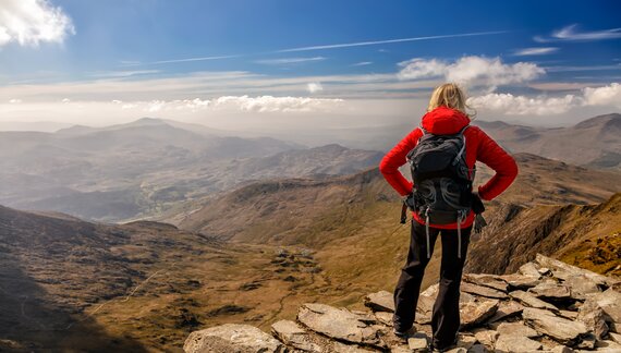 Female hiker in Snowdonia Wales enjoying view of mountainous landscape from high point