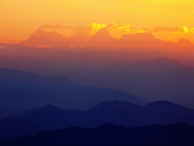 Morning view of Himalayas from the village of Bandipur showing gradient blue, purple, and warm orange silhouette of mountains, Nepal