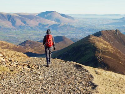 Hiker walking down Scar Crags and Causey Pike, Lake District, UK