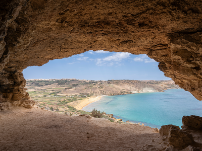 Gozo Island Malta,  View of Ramla Bay, from inside Tal Mixta Cave Gozo looking out over the blue ocean on a bright day