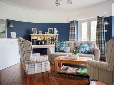 Hassness House living room with repurposed piano now used as makeshift bar