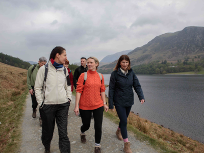 Three women at front of walking group alongside Buttermere Lake