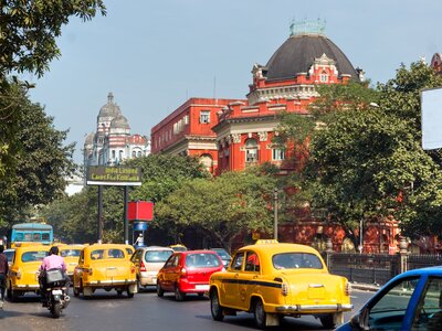 Colourful cars moving along road in Kolkata street, West Bengal, India