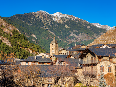 Village of Ordino in Andorra with snow-capped mountain in background on sunny day