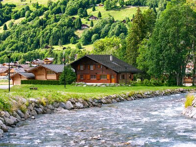 River in Les Diablerets with traditional wooden chalets nearby, Switzerland