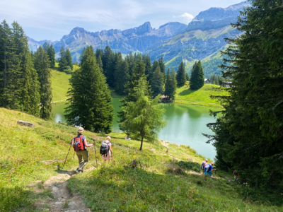 Ramble Worldwide hiking group descending trail towards lake, Les Diablerets, Switzerland