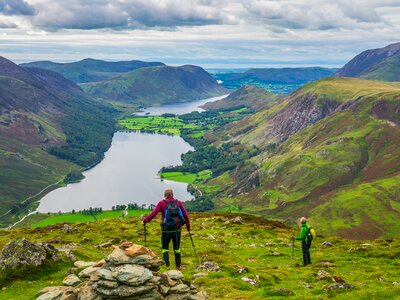 Hikers in Lake District looking at Buttermere lake from Haystacks peak