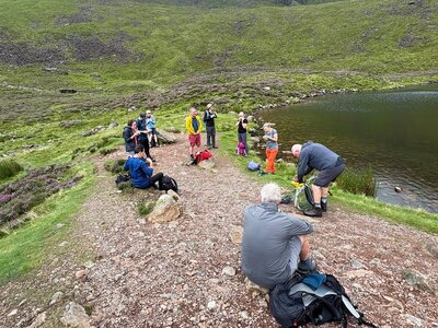 Ramble Worldwide walking group taking break by lake in the Lake District