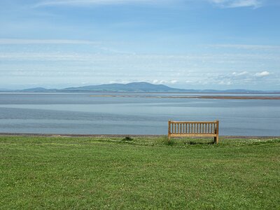 A bench looking over Silloth beach on a nice day, long sand and shingle beach on the Solway Firth, Cumbria