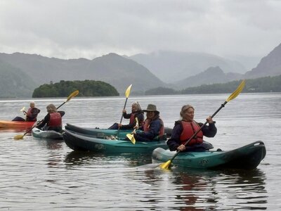Group of women kayaking on lake on Ramble Worldwide holiday Women's activity week in the Lake District