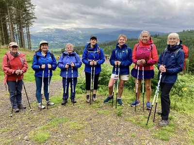 Group of women in Lake District countryside out on walk using waterproof and trekking poles