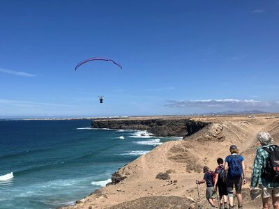 Fuerteventura coast group descent with paraglider over sea