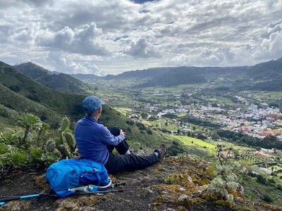 Hiker sat on hillside admiring landscape of Lanzarote